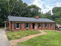 Charming brick home with black shutters, manicured lawn, and inviting walkway at 771 9Th Nw St, Hickory, NC 28601
