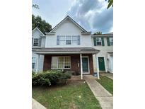 Charming two-story townhouse with brick accents and a covered front porch entrance at 7857 Petrea Ln, Charlotte, NC 28227