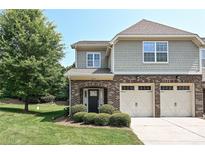 Charming townhome featuring a two-car garage, brick accents, and well-maintained landscaping at 8524 Loxton Cir, Charlotte, NC 28214