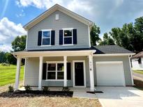 Charming two-story home with gray siding, black shutters, and a welcoming front porch at 907 W Georgia Ave, Bessemer City, NC 28016