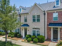 Charming brick townhome with well-maintained landscaping and a welcoming front entrance at 1027 Writers Way, Cornelius, NC 28031