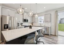 Bright kitchen features stainless steel appliances, shaker cabinets, and a large island with bar seating at 13323 Savaine St, Charlotte, NC 28278