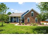 Beautiful brick and siding home with manicured lawn and welcoming front porch at 13733 Castleford Dr, Mint Hill, NC 28227