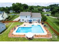 Aerial view of home with large pool, hot tub, patio area, and well-manicured lawn at 13733 Castleford Dr, Mint Hill, NC 28227