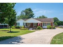 Charming brick home featuring manicured landscaping, long driveway, and inviting front porch perfect for relaxing at 1553 Home Trl # 51, Lincolnton, NC 28092