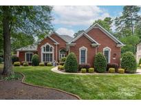 Charming brick home with manicured lawn and mature landscaping creating an inviting curb appeal at 3003 Wedge Ct, Matthews, NC 28104