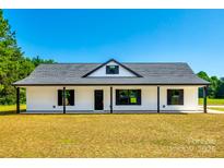 Beautiful white home with black trim, a well-manicured lawn, and a classic gable roof at 3248 Ferguson Long Rd, York, SC 29745