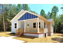 Charming single-Gathering home with a quaint porch and light blue siding in a wooded area at 372 Lippard Farm Rd, Statesville, NC 28625