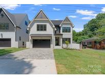 Charming two-story modern farmhouse with stylish brick accents, well-manicured lawn, and paved driveway at 4349 Castleton Rd, Charlotte, NC 28211