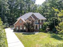 Beautiful two-story brick home with mature trees and a well-manicured lawn at 5051 Carillon Way, Charlotte, NC 28270