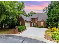 Charming brick home featuring a well-manicured lawn and a spacious driveway leading to an attached garage at 5205 Tedorill Ln, Charlotte, NC 28226