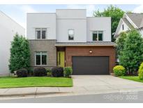 Modern home featuring mixed materials like brick and wood, plus a garage and verdant landscaping at 628 Cherry St, Charlotte, NC 28204