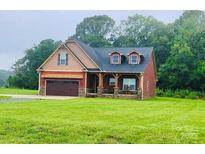 Charming two-story home with a well-maintained lawn and a two-car garage at 670 Cricket Ln, Mt Ulla, NC 28125