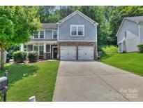 Charming two-story home with a well-manicured lawn and a two-car garage at 113 Missouri Ln, Mount Holly, NC 28120