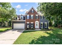 Charming two-story home with a brick and gray siding exterior, featuring a well-manicured lawn and attached garage at 1581 Bluff Ct, Rock Hill, SC 29732