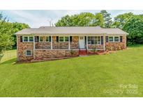 Charming brick home with black shutters and a well-manicured lawn at 1606 N Rhyne St, Gastonia, NC 28054