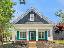 Charming home featuring a beautiful blue exterior with a cozy front porch and white columns at 16815 Spruell St, Huntersville, NC 28078