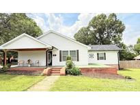Charming single-story home with white siding, a cozy porch, and a well-maintained front yard at 210 W Church St, Cherryville, NC 28021