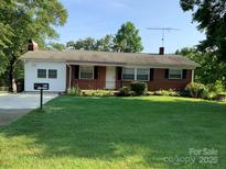 Charming single story home with a brick facade and manicured front lawn and mature landscaping at 3009 Grier St, Newton, NC 28658