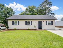 Charming single-story home with a well-manicured lawn, fresh landscaping, and a new roof at 405 Jones Street St, Monroe, NC 28110