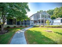 Beautiful two-story home featuring a spacious yard, screened porch, and a welcoming entrance at 47209 Paradise Ln, Norwood, NC 28128
