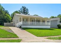 Charming single-story home with a spacious front porch and well-manicured lawn at 5206 Crane Point Dr, Charlotte, NC 28227