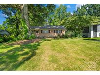 Charming brick home featuring a well-manicured lawn and mature trees for shade and curb appeal at 6632 Candlewood Dr, Charlotte, NC 28210