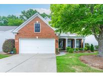 Charming brick home featuring an attached two-car garage, manicured lawn, and mature shade tree at 8637 Annabel Lee Ln, Charlotte, NC 28277