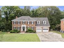 Traditional two-story brick home with black shutters, dormers and a well-manicured lawn at 9605 Mountain Ivy Ct, Charlotte, NC 28210