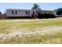 Charming single-story home features a spacious front yard and inviting front porch at 1064 Calico Farm Ct, Cleveland, NC 27013