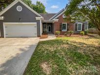 Charming home with a gray exterior, brick accents, a well-manicured lawn, and an attached two-car garage at 11103 Fox Cove Dr, Charlotte, NC 28273