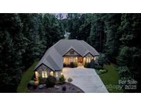 Stunning stone home with lush landscaping and a circular driveway creates an inviting curb appeal at 146 Bullfinch Rd, Mooresville, NC 28117