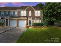 Charming brick townhome featuring an attached garage, well-maintained lawn, and inviting curb appeal at 157 Talbert Town Loop, Mooresville, NC 28117