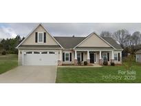 Charming single-story home featuring a covered front porch, manicured lawn, and an attached two-car garage at 275 Dorothy Dr, China Grove, NC 28023
