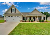 Charming home with a manicured lawn, a two-car garage, and a welcoming front entrance with columns at 275 Dorothy Dr, China Grove, NC 28023
