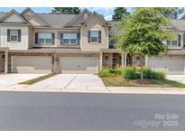 Charming townhome with a two-car garage, stone accents, and manicured landscaping creates excellent curb appeal at 3159 Hartson Pointe Dr, Fort Mill, SC 29707