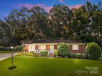 Charming red brick home featuring a lush front lawn and mature trees at 331 Elwood St, Kannapolis, NC 28081