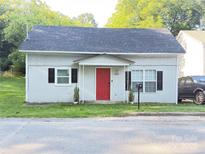 Charming bungalow with a bright red door, complemented by black shutters and manicured landscaping at 409 W Norment Ave, Gastonia, NC 28052