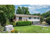 Charming home featuring a well-maintained lawn, a wooden deck, and a classic American flag at 4278 Harbor Ln, Sherrills Ford, NC 28673