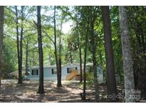 Charming single-story home features a classic facade with inviting front porch and lush, wooded surroundings at 561 Woodglenn Rd, Catawba, SC 29704