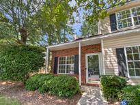 Charming two-story home features a brick facade, complemented by lush landscaping and a welcoming front entrance at 9121 Charminster Ct, Charlotte, NC 28269