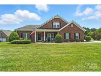 Charming brick home with a manicured lawn and inviting front porch at 1006 Spring Rose Ln, Matthews, NC 28104
