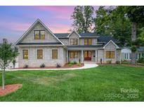 Beautiful two-story home featuring a manicured lawn, complemented by a stylish brick facade and a welcoming entryway at 101 Mcalway Rd, Charlotte, NC 28211