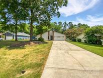 Charming single-Gathering home boasts a two-car garage, beautiful lawn, and mature trees at 10934 Coachman Cir, Charlotte, NC 28277