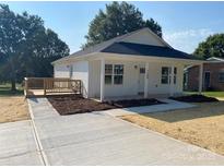 Charming home featuring a neatly landscaped yard, a cozy porch, and a freshly paved driveway at 1103 Adams St, Statesville, NC 28677