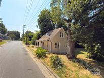 Charming home with a tan exterior, surrounded by mature trees and greenery at 179 Duval Nw St, Concord, NC 28025