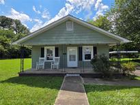 Charming single-story home with a cozy front porch and well-maintained lawn at 227 Nassau Pl, Mount Holly, NC 28120