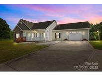 Charming home with stone accents, covered porch, and an attached two-car garage at dusk at 307 Nc Hwy 49 S Hwy, Richfield, NC 28137
