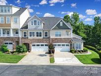 Beautiful townhome with stone accents, two-car garage, and manicured lawn, perfect for comfortable living at 329 Wave Crest Dr, Tega Cay, SC 29708