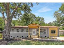 Charming home featuring a covered porch, gray siding, and a well-manicured front yard at 4219 Tipperary Pl, Charlotte, NC 28215